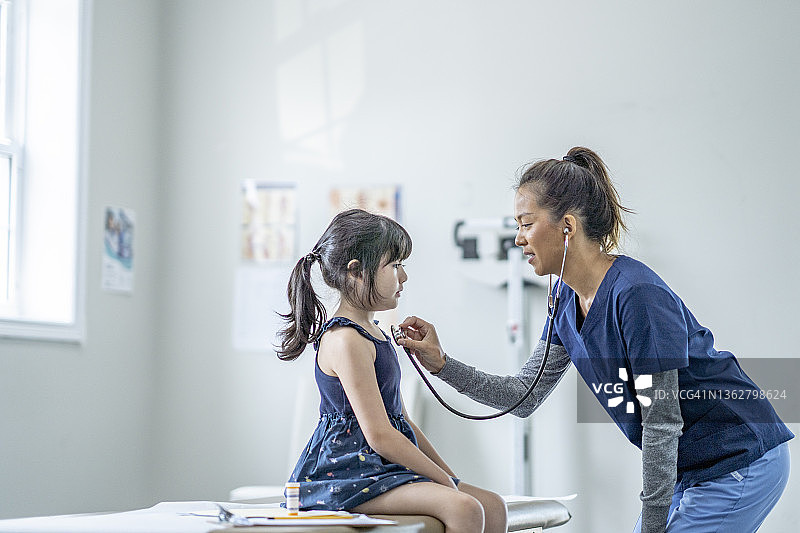 医生正在听小女孩的心跳图片素材