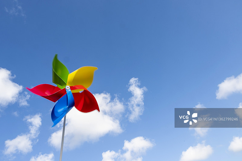 在天空背景下随风飘动的彩色风车图片素材