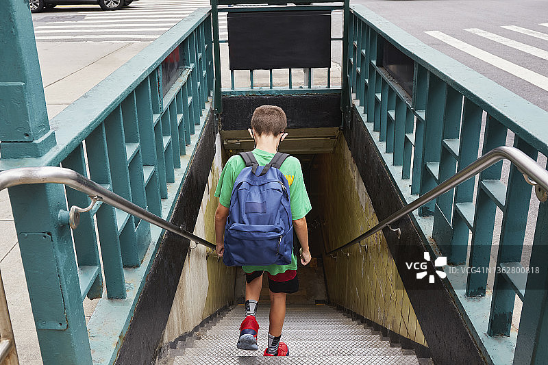 美国纽约：背着背包上学男孩（8-9岁）进入地铁图片素材