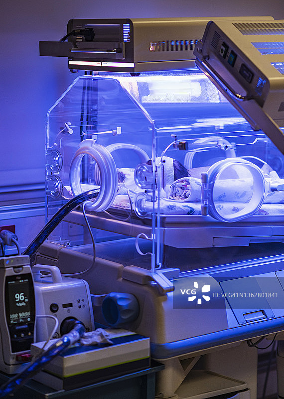 在保育箱中接受黄疸治疗的女婴（0-1个月）图片素材