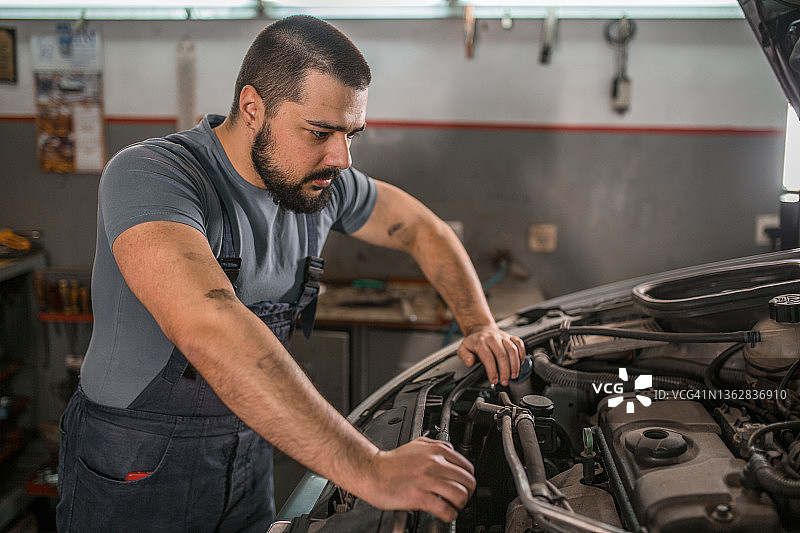 专心检查发动机的汽车修理工图片素材