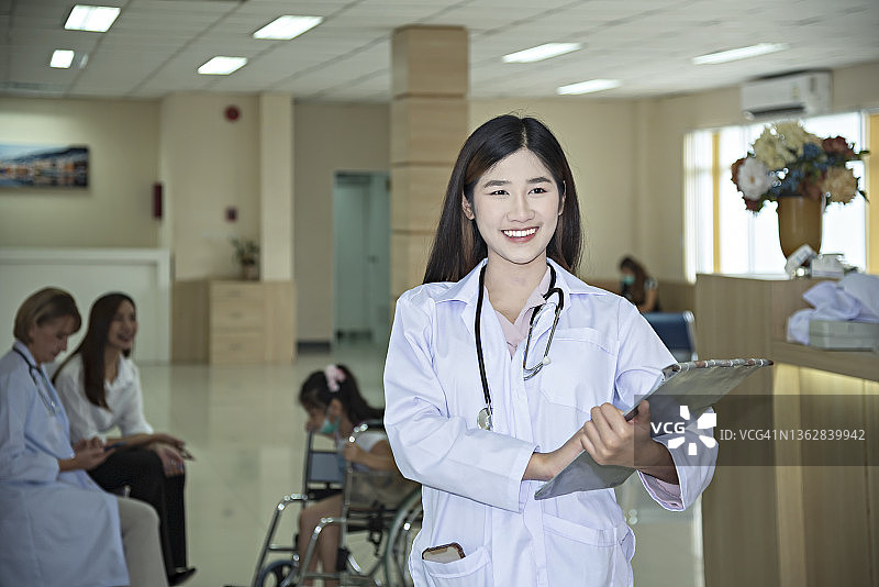 女医生在医院里和病人交谈时面带微笑。图片素材