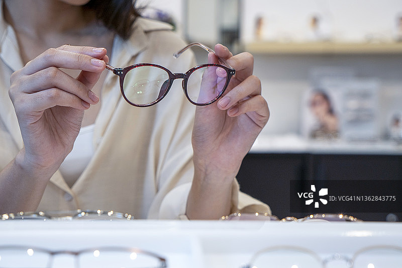 配镜师为顾客挑选处方眼镜图片素材