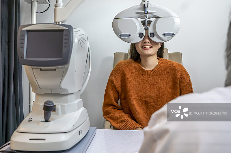 眼科诊所：女性使用现代设备检查视力图片素材