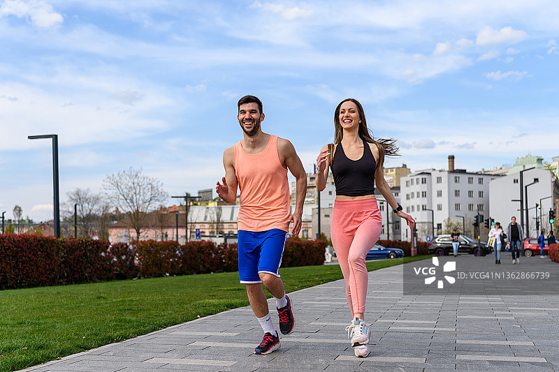 年轻的运动员情侣正在穿过城市图片素材