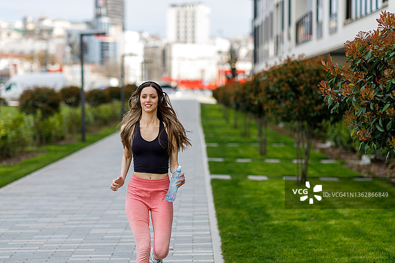 在城市中跑步的漂亮女运动员图片素材