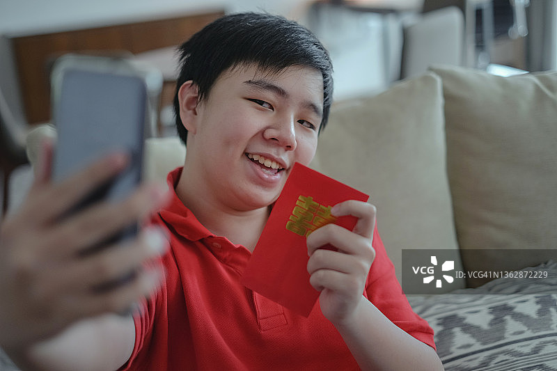 中国青少年在春节视频通话中展示红包图片素材