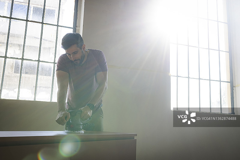 制作家具的英俊白人建筑师，打磨木制抽屉柜图片素材