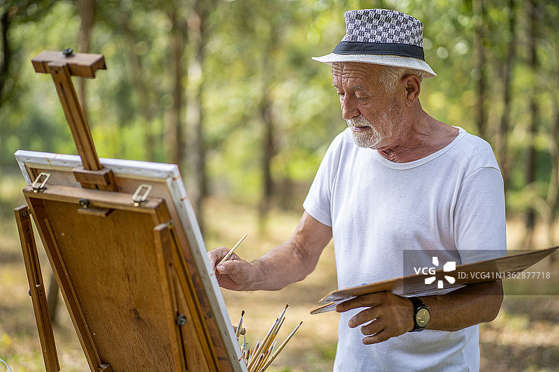 独自在自然公园户外写生的老年男人图片素材