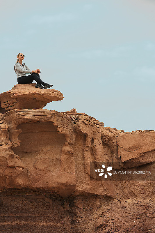 坐在红色荒野山区的女人图片素材