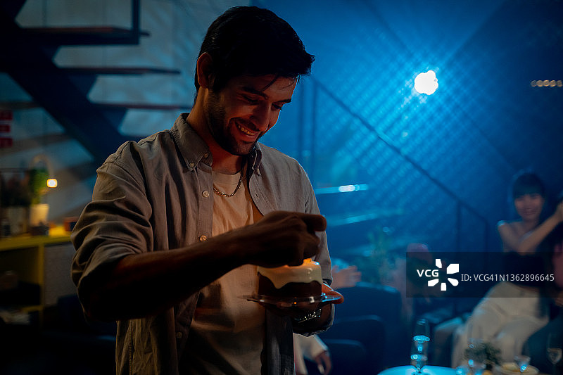 男子在纸杯蛋糕上点燃蜡烛图片素材