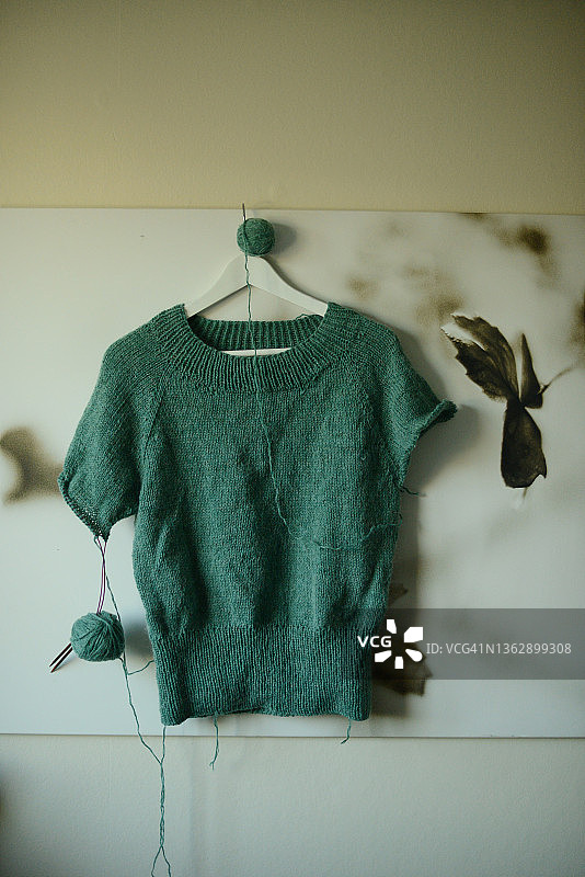 挂在墙上的蓝绿色针织毛衣图片素材