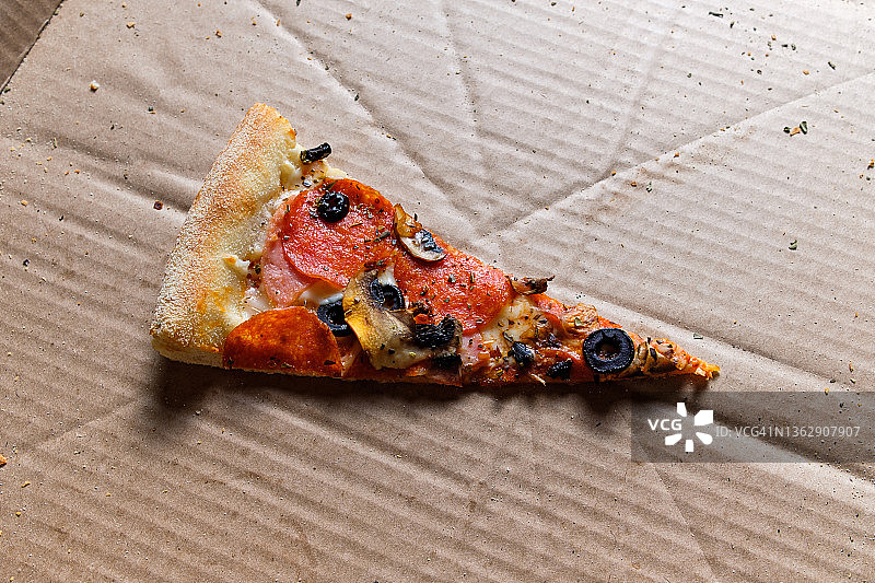 美味的意大利披萨：外卖披萨盒装，白色背景。番茄、意大利辣香肠、培根和奶酪披萨切片，不健康的生活方式快餐理念。图片素材