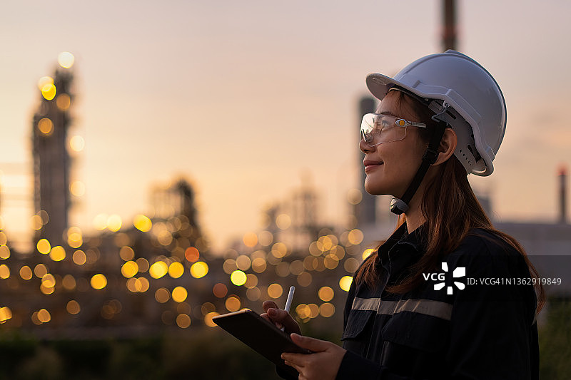 石油天然气工业工程师检查设备（含个人防护装备），并使用平板电脑对照检查清单图片素材