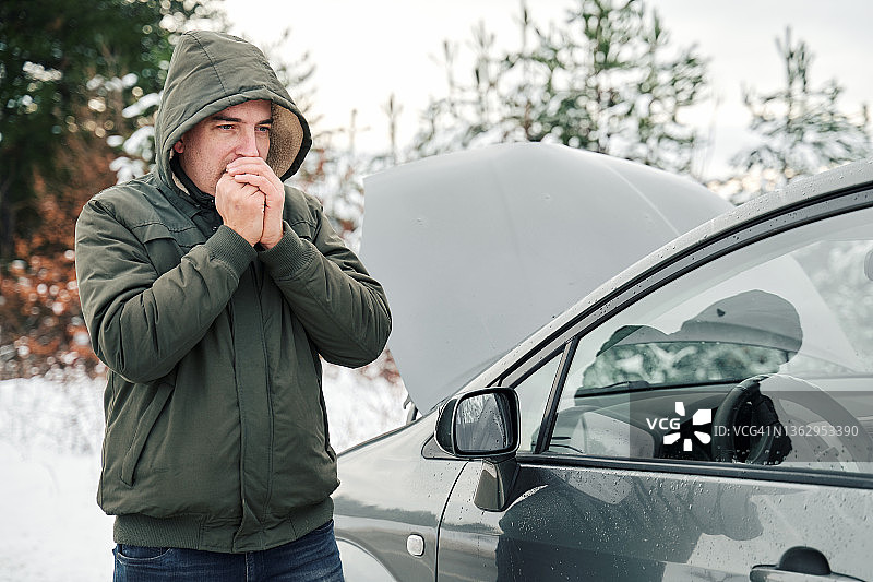 冬天，男子站在抛锚的汽车旁图片素材