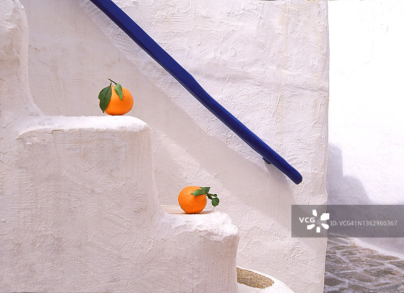 摆放在白色台阶上的两颗橘子图片素材