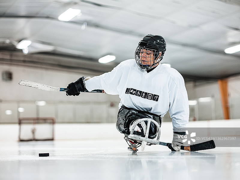 中年残障拉丁裔女人玩雪橇曲棍球图片素材