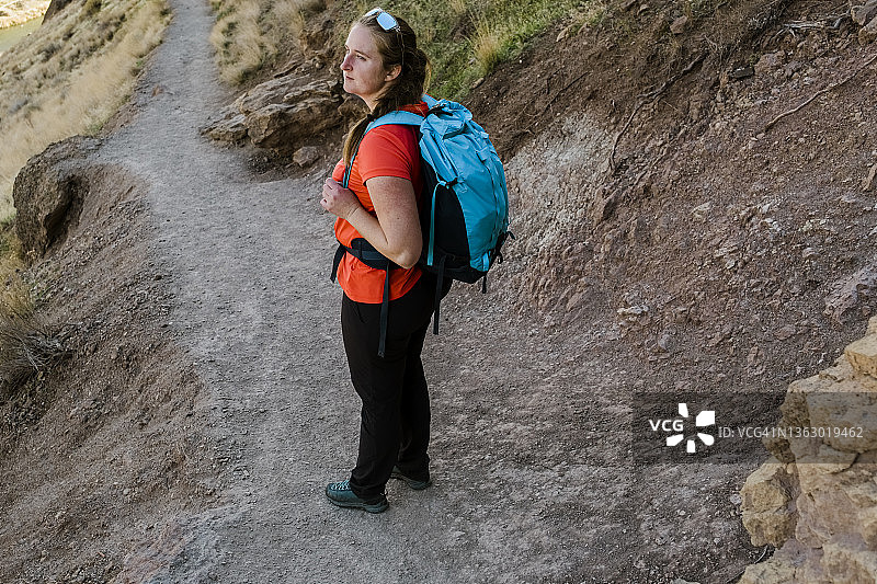 一位女徒步者走在俄勒冈州史密斯罗克公园的土路上图片素材