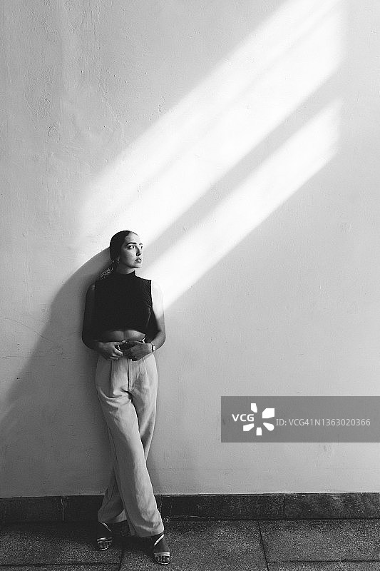 站在墙边抬头看的巴西女子黑白全身像图片素材