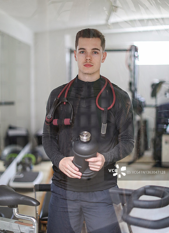 在南非开普敦的家庭健身房中锻炼的年轻白人男子肖像图片素材