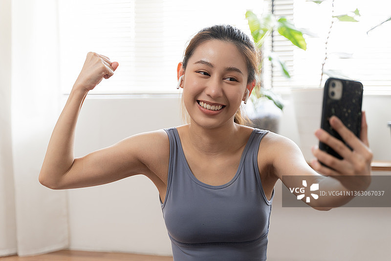 运动后用智能手机自拍的年轻亚裔女性图片素材