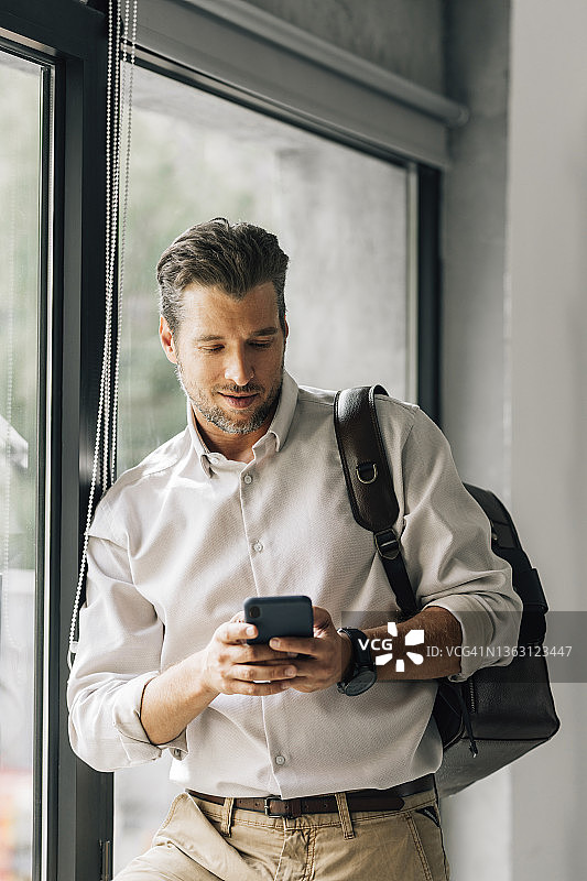 在图书馆使用手机的英俊老师图片素材