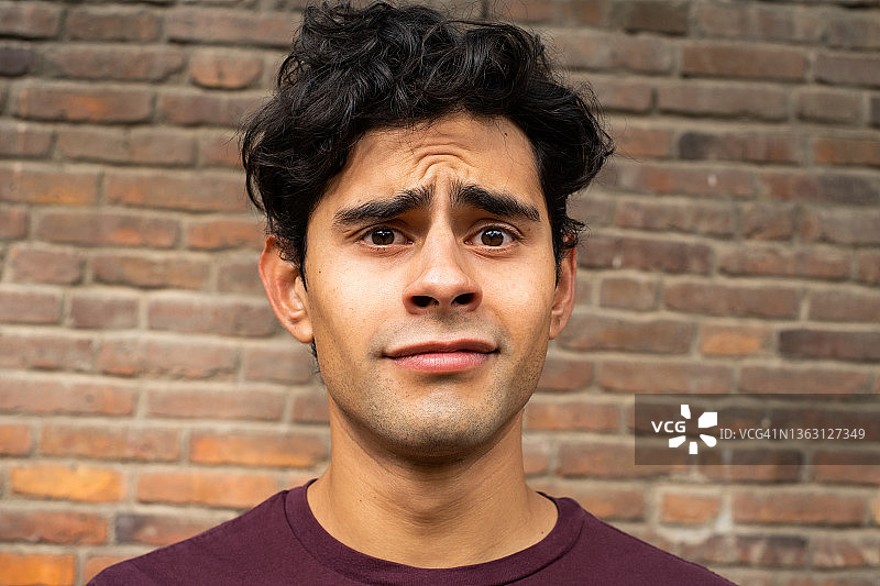 面部表情不确定、困惑的年轻拉丁裔男人图片素材