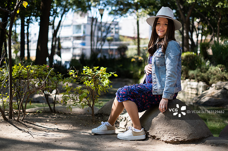 一位年轻的怀孕犹太妇女在日本花园中摆姿势图片素材