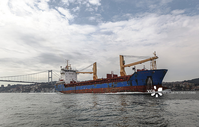 在土耳其伊斯坦布尔博斯普鲁斯海峡航行的大型商用货船图片素材