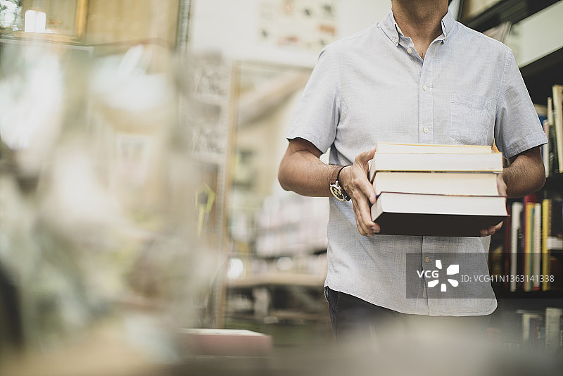 男人在书店里拿着书走路图片素材