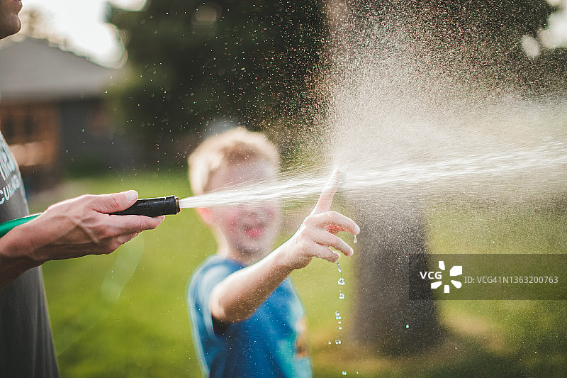 站在水雾后面的男孩图片素材