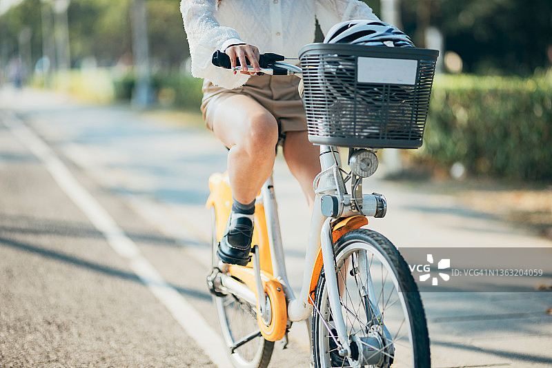 亚洲女性在市中心租用共享单车去上班图片素材