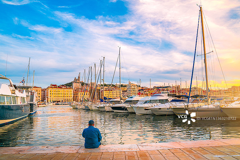 男人坐在河边的木制码头上图片素材