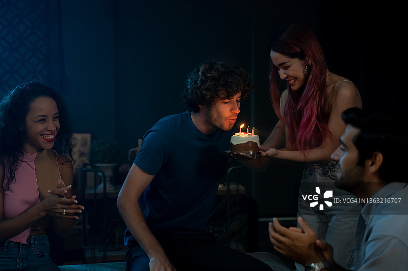 男人在家里的聚会上给女人送生日蛋糕图片素材