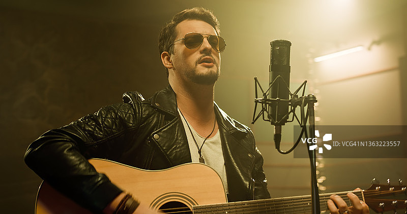 在录音棚弹吉他的男歌手图片素材