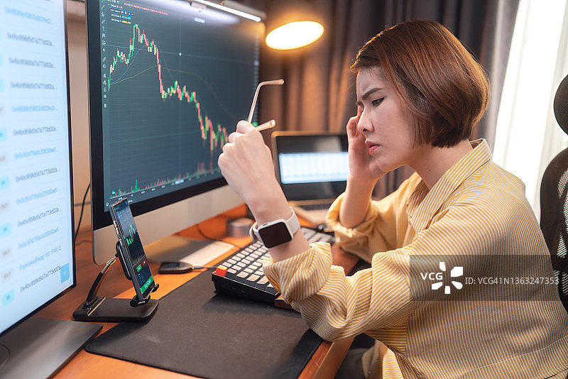 因商业金融危机和在线股票、加密货币投资交易而感到压力的女人，去中心化和股市概念图片素材