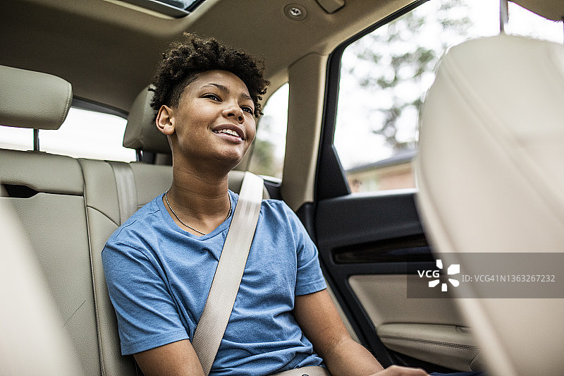 坐在汽车后座的青少年男孩图片素材