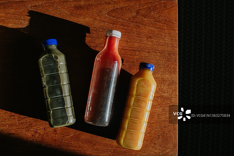 俯视角度拍摄的三瓶不同口味的鲜榨果汁图片素材