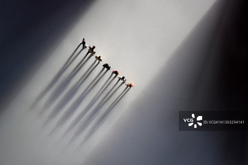 阳光下的概念，从正上方投下的长长的阴影图片素材