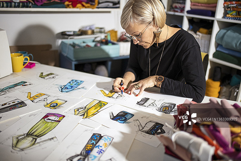 年轻女设计师在设计桌上绘制创意图片素材