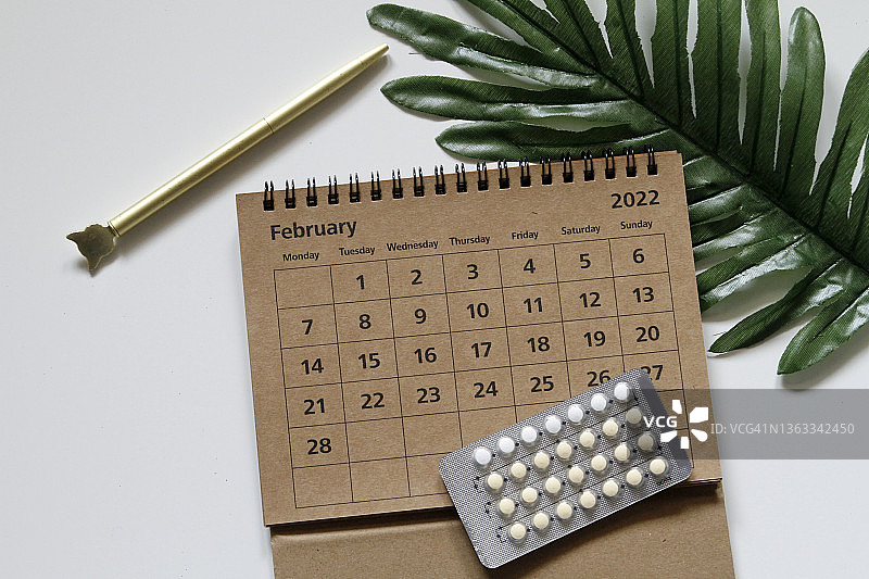 办公桌上的2022年2月日历和避孕药包装图片素材