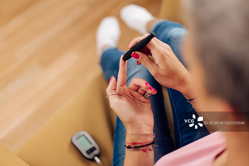 在家做血糖测试的女人图片素材