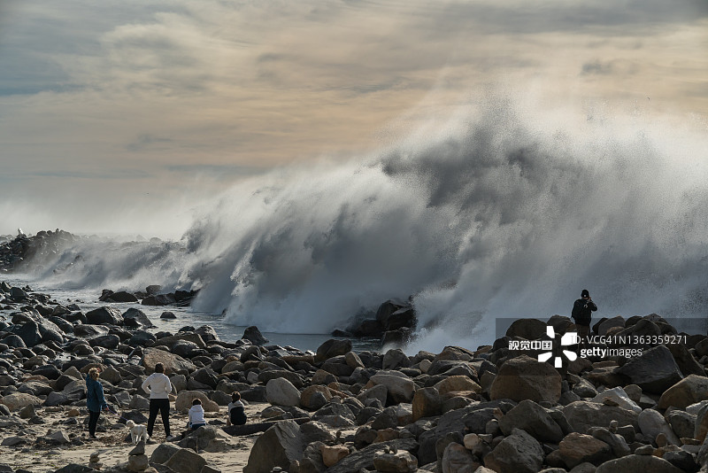 暴风雨中海浪拍向空中，人们欣赏着美景图片素材
