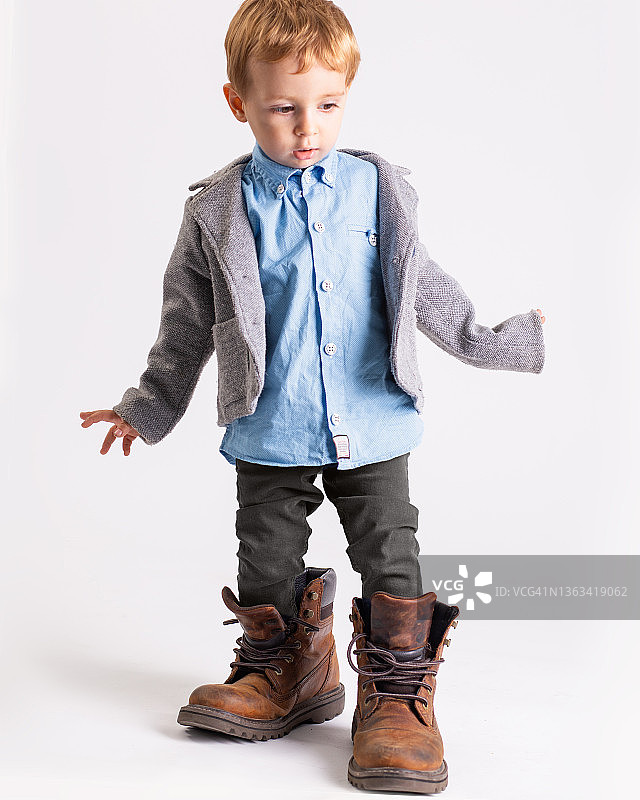 2岁男孩穿着父母的鞋子走路图片素材