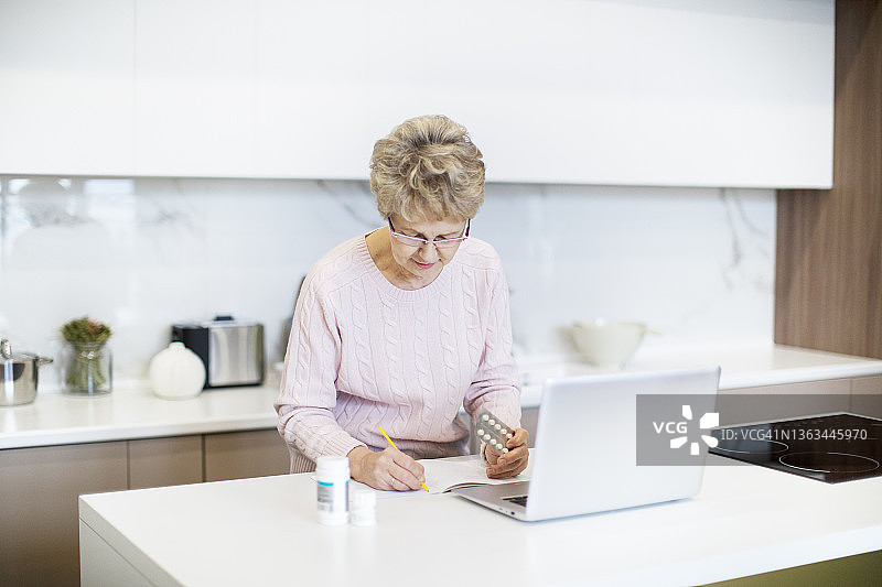 积极的老年妇女通过互联网咨询医生关于药丸图片素材