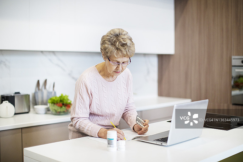 积极的老年妇女通过互联网咨询医生关于药丸图片素材