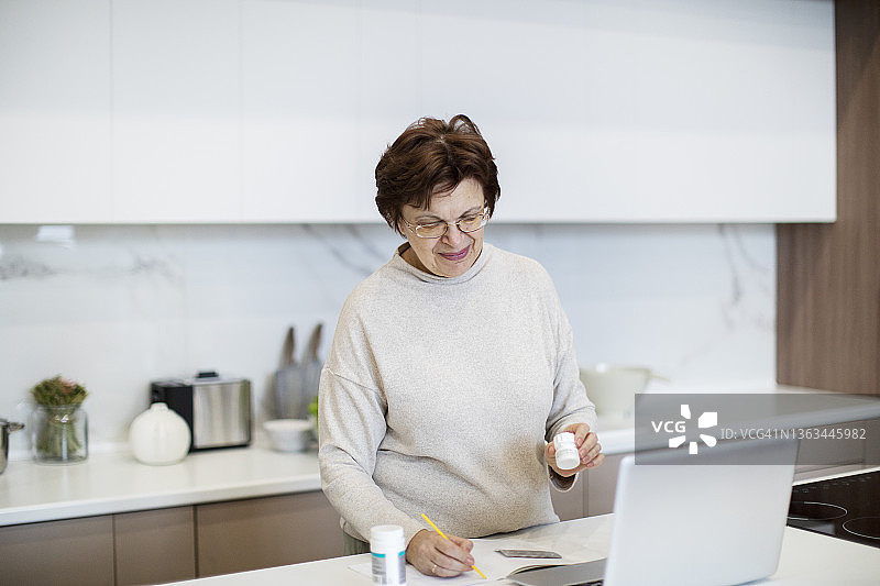 积极的老年妇女通过互联网咨询医生关于药丸图片素材