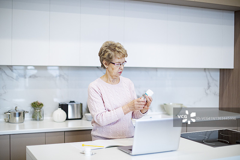 积极的老年妇女通过互联网咨询医生关于药丸图片素材