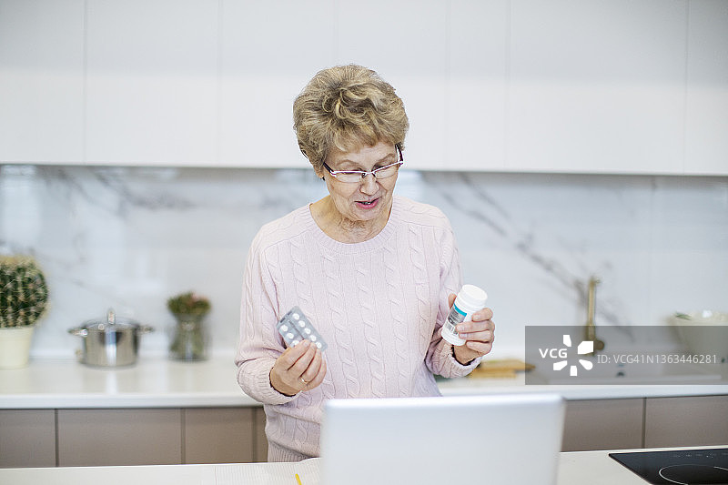 积极的老年妇女通过互联网咨询医生关于药丸图片素材