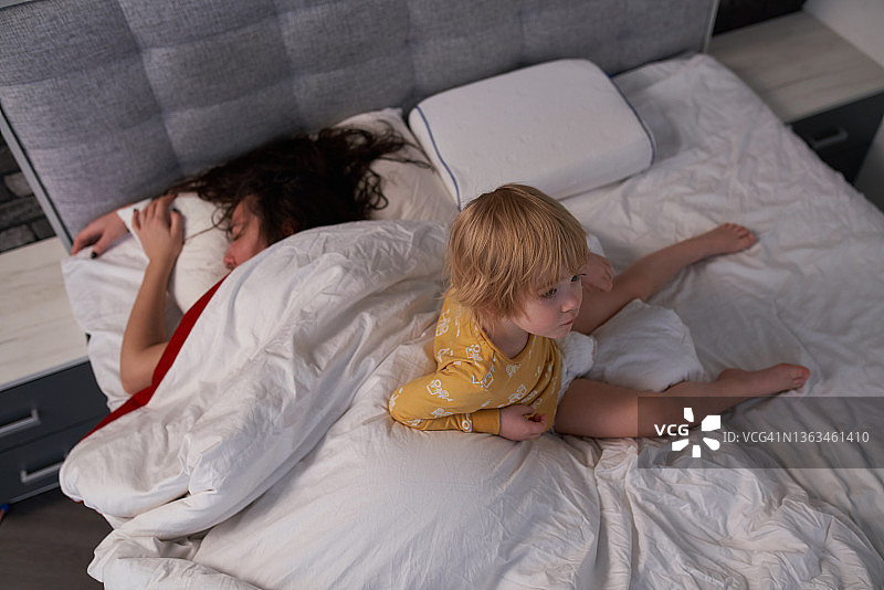 孩子坐在床上靠近母亲图片素材